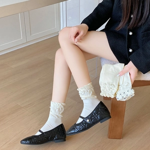 Detail weißer Rüschensocken mit Perlen kombiniert mit schwarzen Stepp-Ballerinas