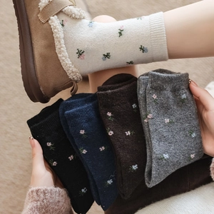 Detailed close-up of thick floral embroidered wool socks in five assorted autumn colors