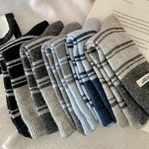Detailed texture of thick striped knit wool socks with decorative white fabric labels