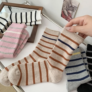 Detailed knit texture of pink and grey striped crew socks with ribbed cuffs