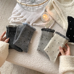 Detailed view of cozy wool socks with polka dots and ruffled edges in assorted colors