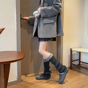 Détail de jambières en maille épaisse avec design contrasté bicolore gris et noir chic