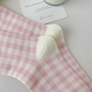 Detail shot of pink and white checkered knit socks with soft cotton texture and pattern