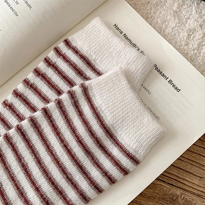 Close-up of vintage striped wool socks with ribbed cuffs on a rustic wooden background