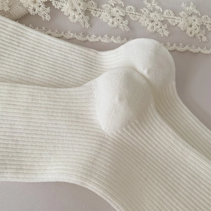 Detailed close-up of the ribbed knitting texture and heel on white cotton socks