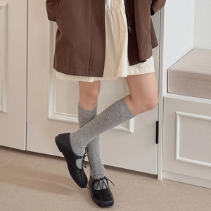 Detailed texture of thick vintage grey mid-calf socks paired with black lace-up shoes