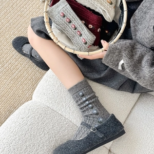 Detailed close-up of floral embroidery on thick knit wool socks for autumn and winter wear