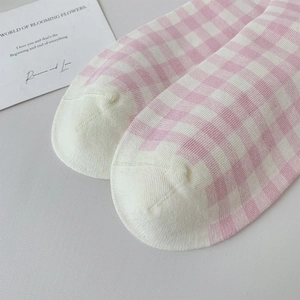 Close-up of pink and white checkered knit socks with soft cotton texture and fine stitching
