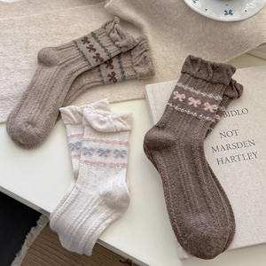 Detail der Strickstruktur von Fair Isle Wollsocken mit Schleifenmuster und Spitzenborte