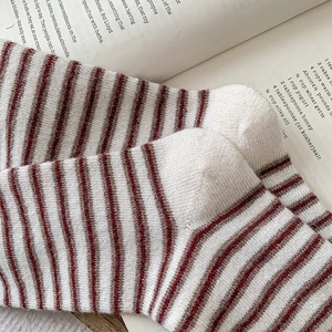 Detailed knit texture of burgundy striped wool socks on vintage book page