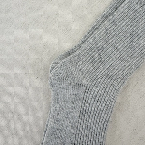 Close-up of gray ribbed wool socks showing thick knitted texture and heel craftsmanship