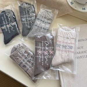 Detail der Fair-Isle-Wollsocken im Set mit Schleifen und Zip-Verpackung in gemütlicher Deko