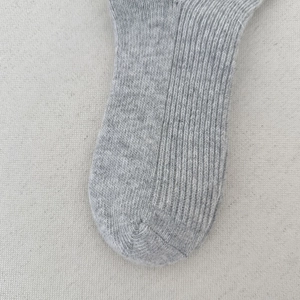 Detailed close-up of grey ribbed wool socks showing the premium knit texture and stitching