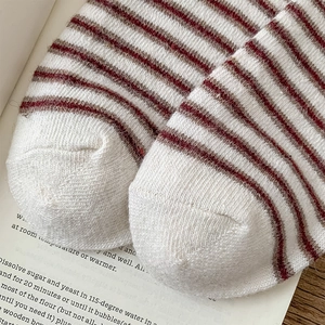 Close-up of red and white striped wool socks showing detailed knit texture and toe seam