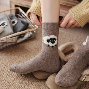 Détail de chaussettes en laine marron chaud avec motif mouton mignon pour l'hiver