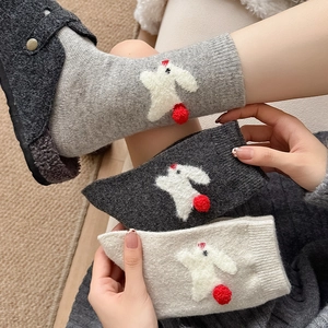 Detail of cute 3D bunny design and red pom-pom on warm thick wool crew socks