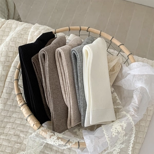 Detailed knit texture of rib-knit mid-calf socks in five neutral earth-tone colors