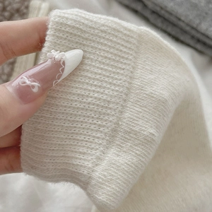 Close-up of thick ribbed knit texture on cream-colored warm vintage calf socks
