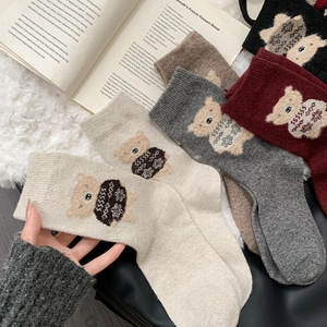 Detailed knit texture of wool socks featuring cute 3D flocking teddy bear patterns