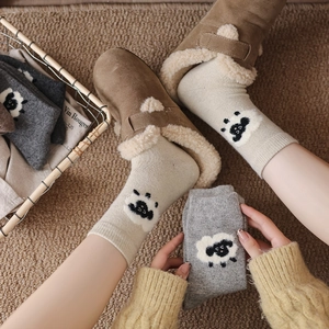 Gros plan du motif mouton sur des chaussettes épaisses en laine côtelée beige et gris