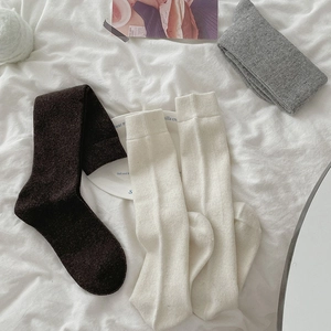 Detailed knit texture of thick winter calf socks in brown, cream and grey colors