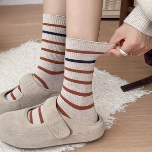 Close-up of elastic ribbed cuff on brown and navy striped cotton crew socks
