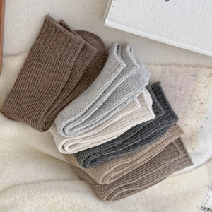 Detail of assorted warm wool socks with vertical knit stripes in neutral winter tones