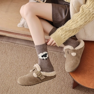 Gros plan de mules en daim avec doublure en fausse fourrure et chaussettes motif mouton