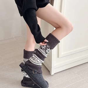 Detail of Fair Isle knit leg warmers with snowflake pattern and ribbed cuffs for winter