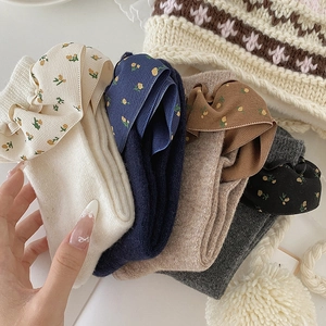 Detail von Wollsocken mit floralen Schleifen in Creme, Marine, Kaffee und Dunkelgrau