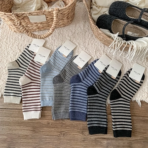 Detailed set of six striped wool socks displayed on a warm home background