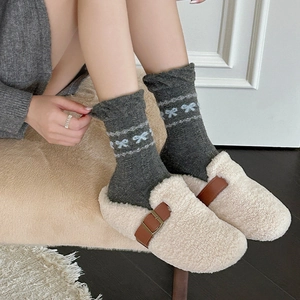 Fair-Isle-Wollsocken mit blauen Schleifenmustern und beigen Plüschhausschuhen