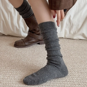 Deep grey knitted slouch socks with rib pattern paired with brown leather boots