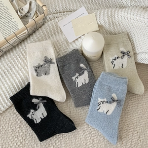 Detail of wool socks featuring cat jacquard and plaid ribbon bows in five soft colors