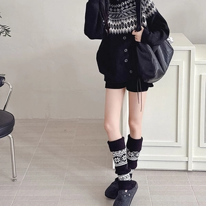 Close-up of Nordic Fair Isle leg warmers styled with grey clogs and knitwear