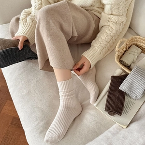 Detail of multi-color wool crew socks with vertical knit texture in a cozy home setting