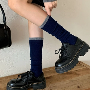 Navy blue wool socks with grey contrast cuff paired with platform leather boots