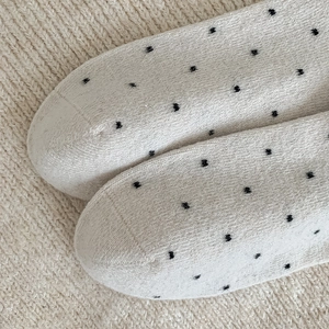 Close-up of knitted polka dot wool socks with reinforced toe stitching and soft texture