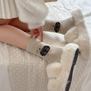 Close-up of cute flocked bear pattern on thick knit wool crew socks for winter
