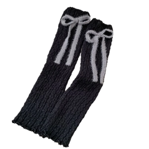 Scaldamuscoli in maglia nera con fiocco in peluche grigio e bordi con volant