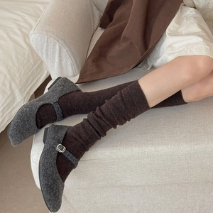Detail of dark brown knitted calf socks paired with vintage charcoal grey Mary Jane shoes