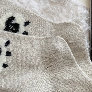 Détail macro de chaussettes en laine épaisse avec broderie de mouton en relief 3D