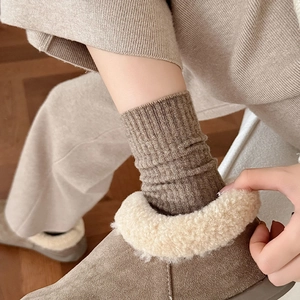 Detailed texture of thick vertical rib knit wool socks paired with fur-lined boots