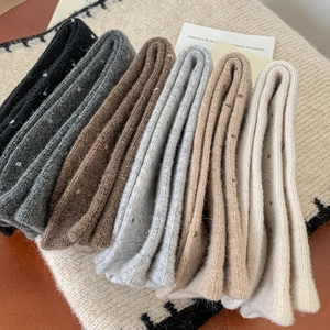 Detail view of thick knit wool socks in neutral tones with soft ribbed texture