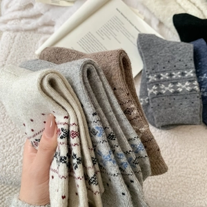 Dettaglio della maglia di calze vintage in lana con motivi nordici e fiocchi di neve