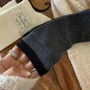 Detailed shot showing the elastic contrast cuff and thick wool knit texture of these warm socks
