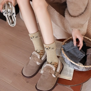Detail of wool-blend cat socks with cute ear jacquard and paw prints in warm colors