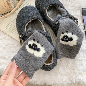 Détail de chaussettes en laine à motif mouton et de chaussures Mary Jane en feutre
