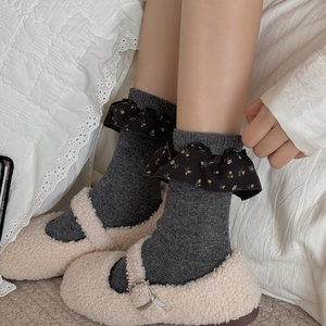Dunkelgraue Socken mit schwarzen floralen Spitzenborten und flauschigen Schuhen