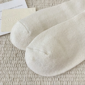Close-up of the reinforced toe seam and dense knit texture of cream wool socks